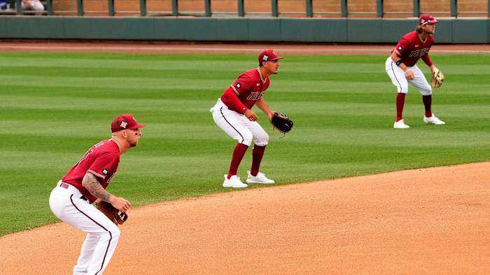 Three baseball defenders line up in a shift
